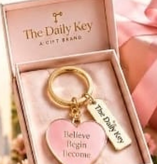 A blush heart keychain resting in an open gift box