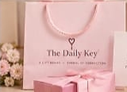 The Daily Key blush gift bag with a pink ribbon handle